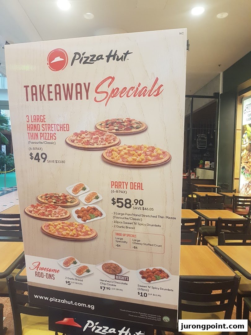 A Pizza Hut menu board displaying takeaway specials, party deals, and add-ons with prices.