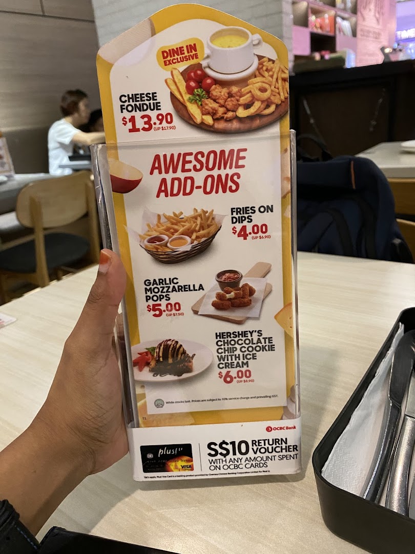 A close-up of a Pizza Hut menu stand displaying exclusive dine-in offers and awesome add-ons.
