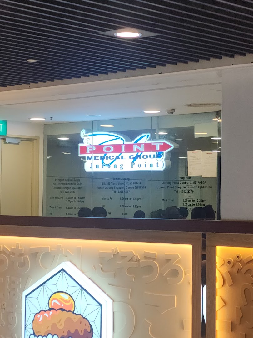 The illuminated storefront of Point Medical Group, a medical clinic located at Jurong Point.