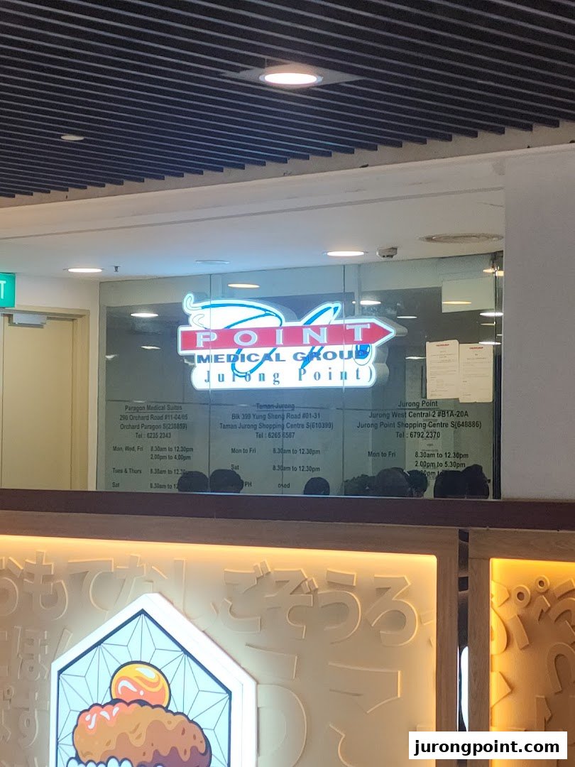 The illuminated storefront of Point Medical Group, a medical clinic located at Jurong Point.