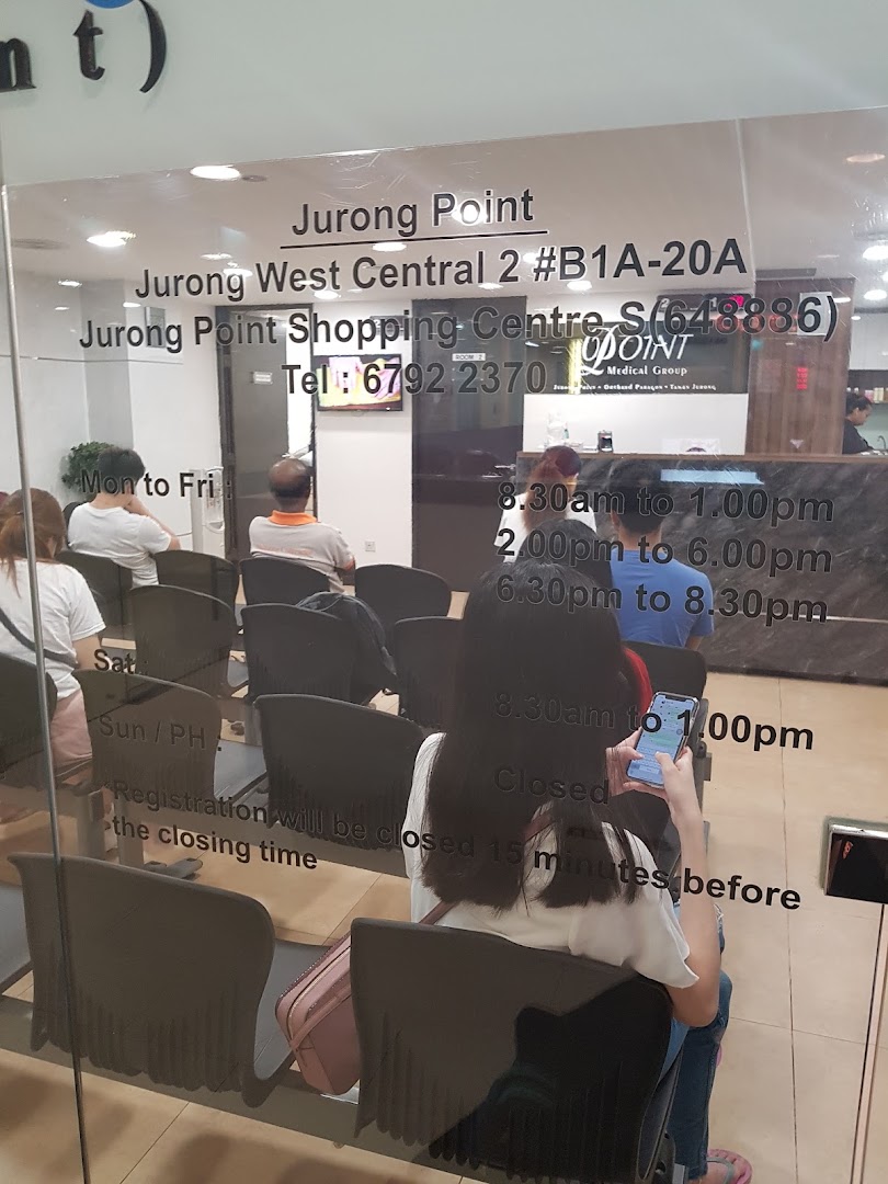 Interior view of Point Medical Group clinic with patients waiting in the reception area.