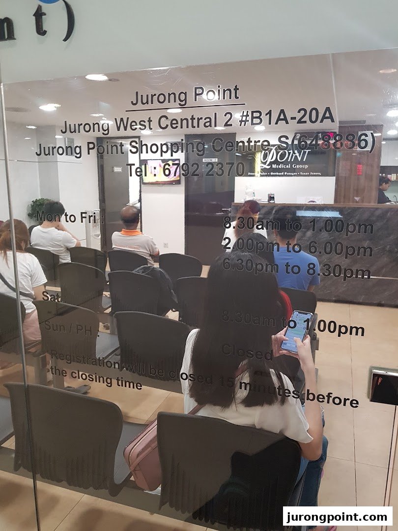 Interior view of Point Medical Group clinic with patients waiting in the reception area.