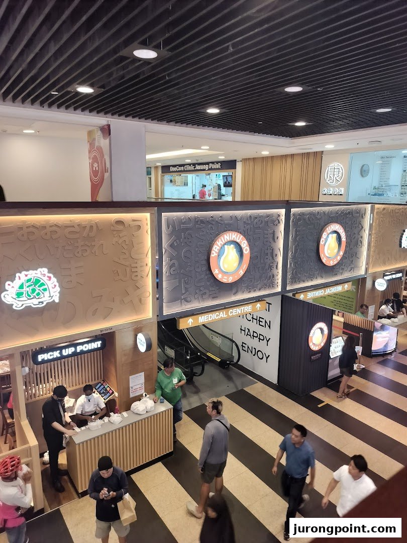 An overhead view of a bustling mall interior featuring various shops and a medical clinic.
