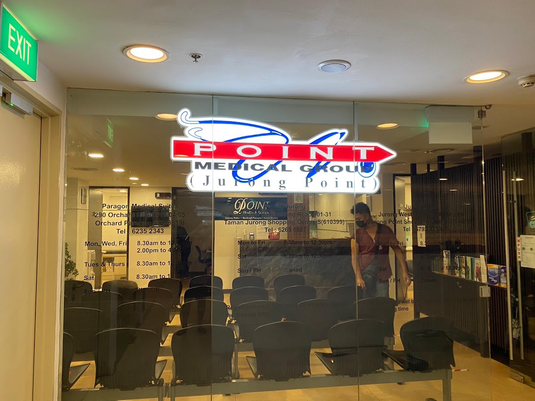 The glass entrance of Point Medical Group at Jurong Point, featuring its logo and interior waiting area.