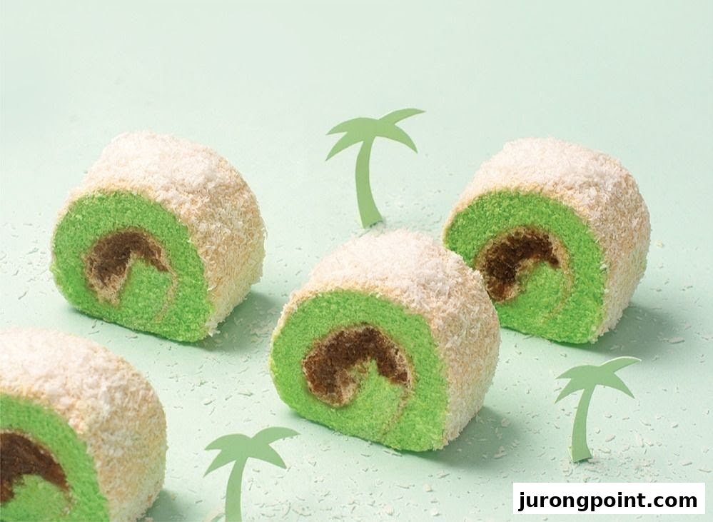 Several green and brown swiss rolls covered in coconut flakes, with paper palm tree decorations on a light green background.