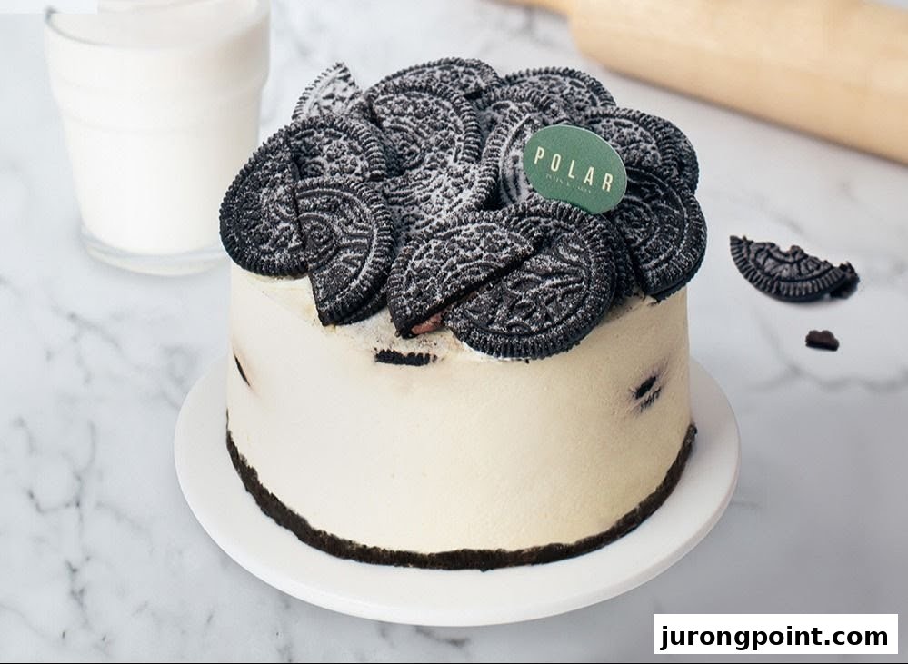 A delicious white cake topped with Oreo cookies and powdered sugar, featuring the Polar Puffs & Cakes logo.