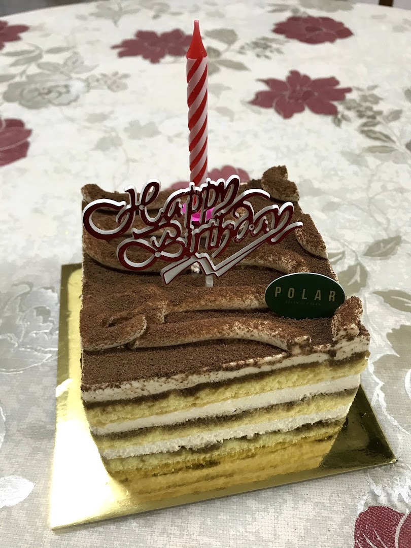 A delicious slice of tiramisu cake from Polar Puffs & Cakes with a birthday candle.