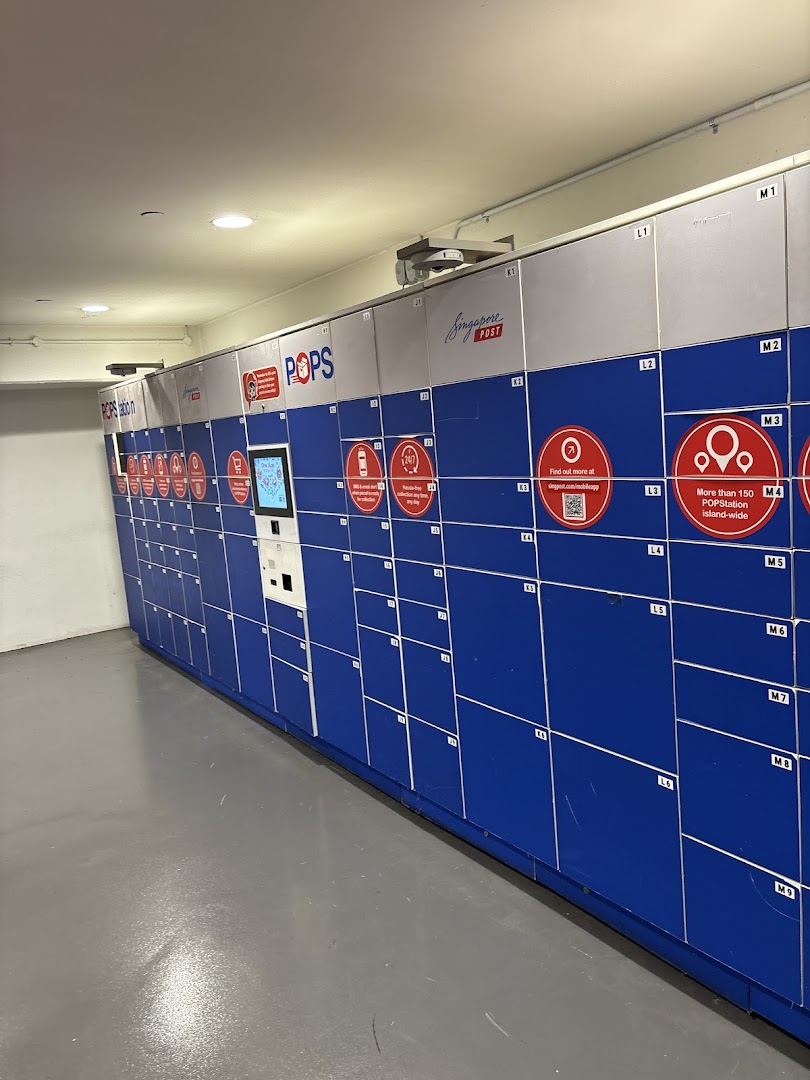 A long row of blue and white POPStation parcel lockers with a central interactive kiosk.
