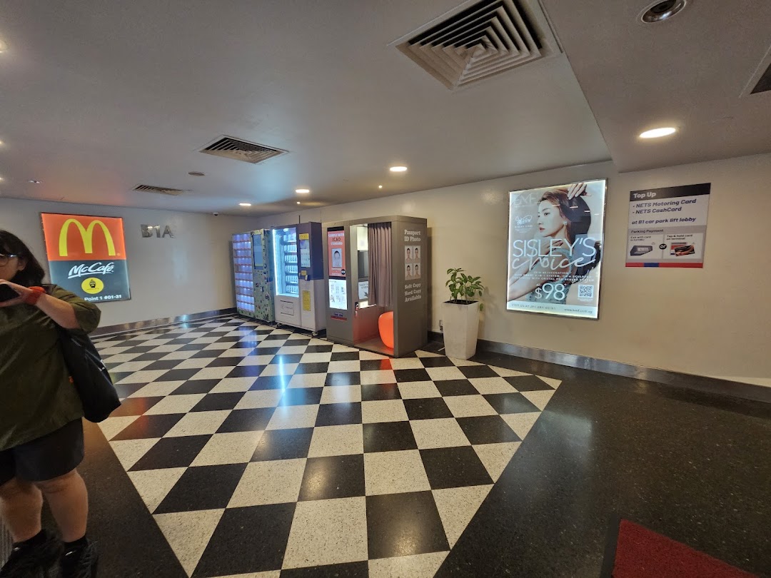 An indoor mall area featuring vending machines, a photo booth, and various self-service amenities.