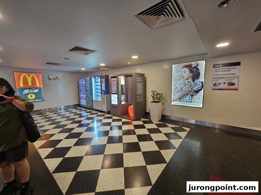 An indoor mall area featuring vending machines, a photo booth, and various self-service amenities.
