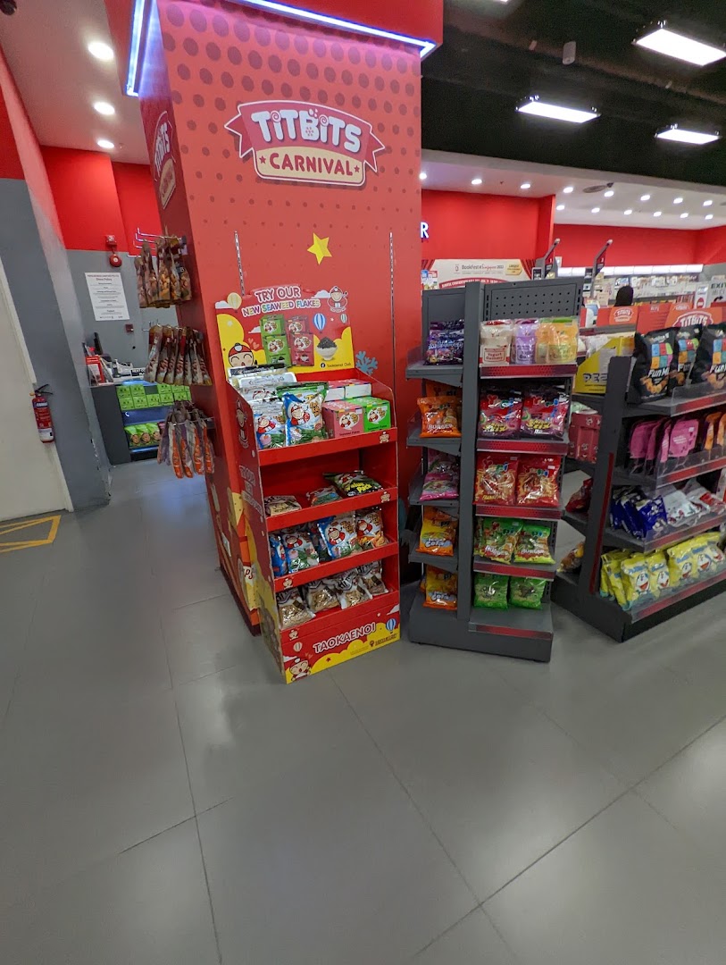 Vibrant snack displays and promotional stands inside a retail store, featuring Titbits Carnival and Taokaenoi products.