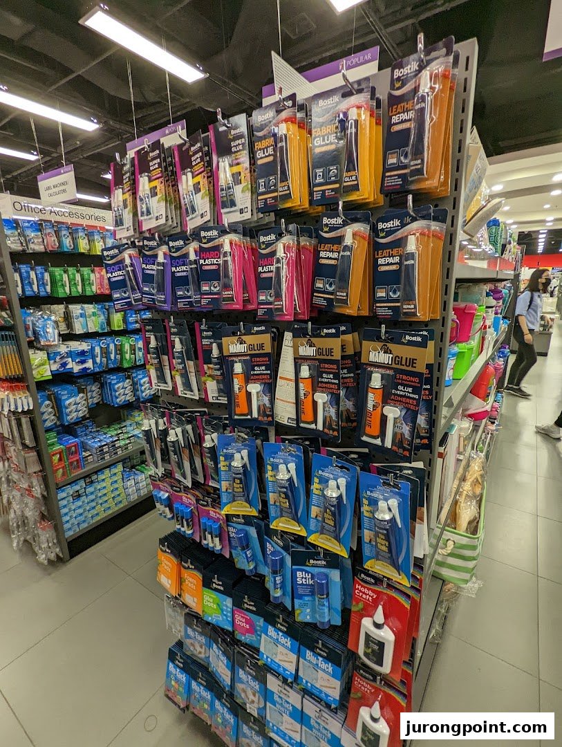 A retail display showcasing various Bostik glues and adhesives, alongside other office accessories.