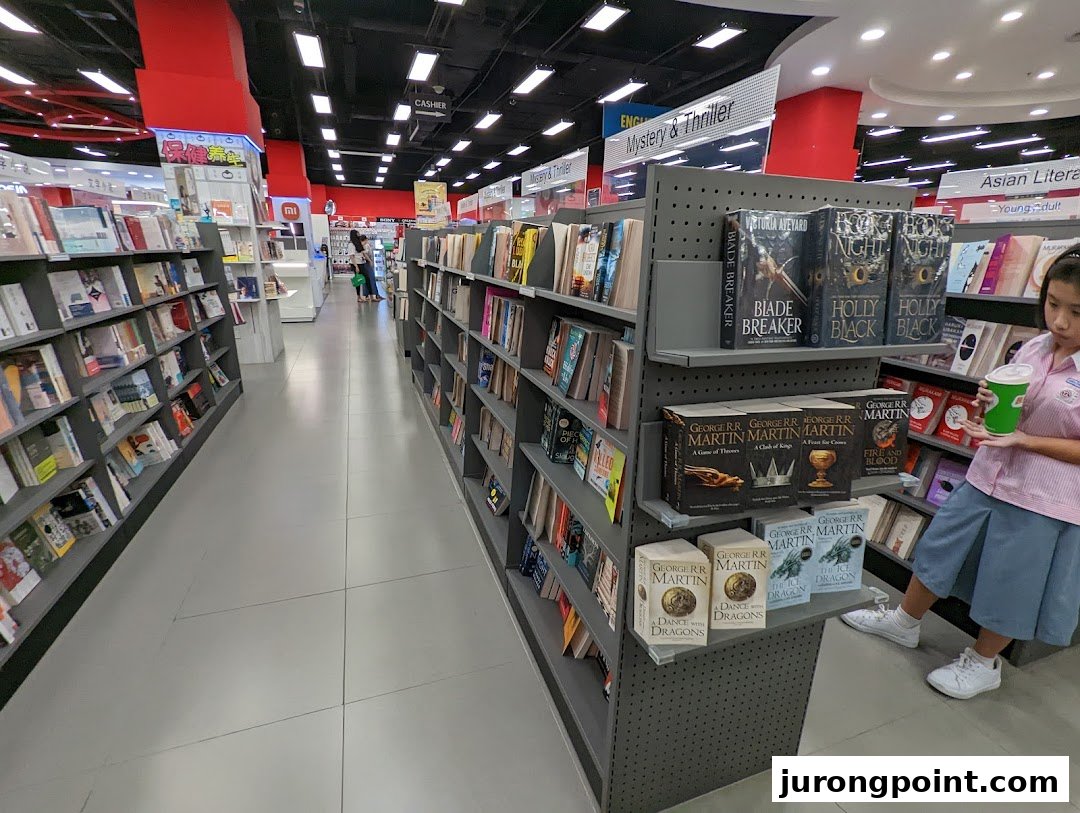 Interior view of POPULAR Bookstore with shelves of books and a customer browsing.