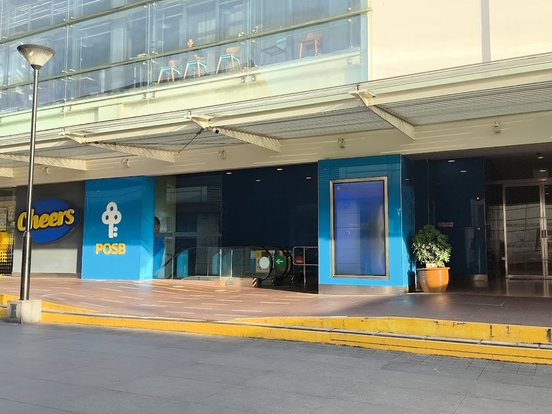 Exterior view of POSB Jurong Point Branch entrance, featuring an escalator and adjacent Cheers convenience store.