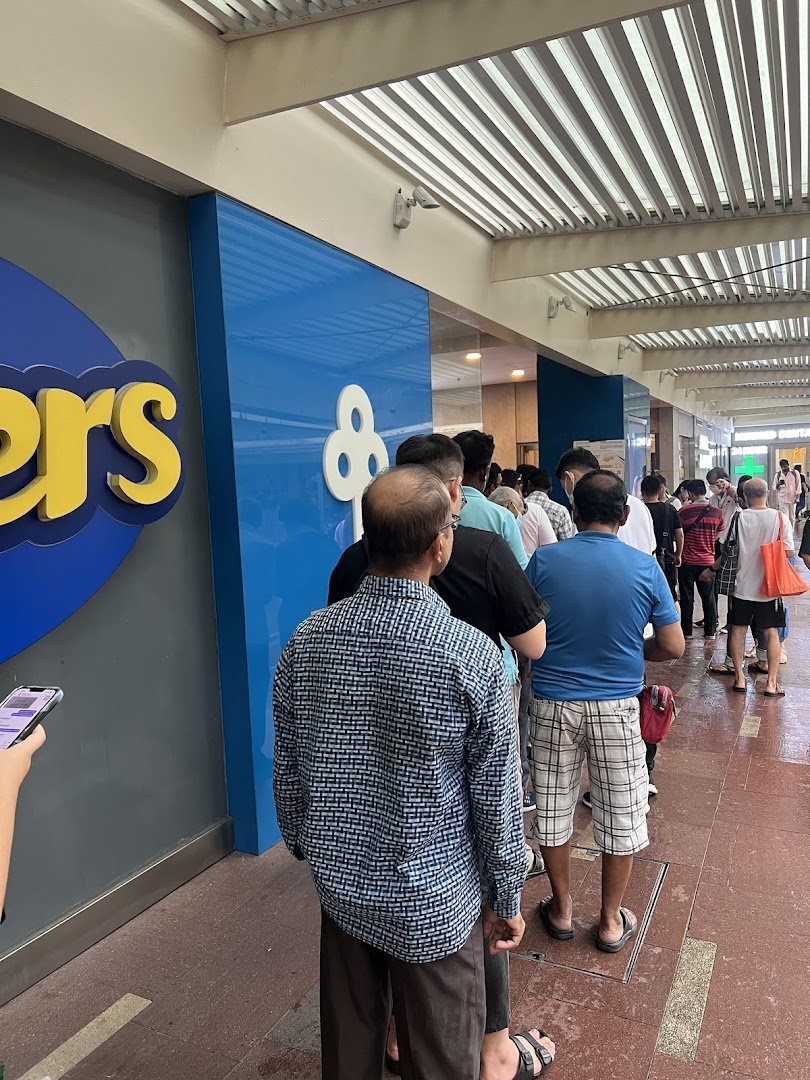People queueing outside the POSB Jurong Point Branch, visible with its blue and yellow signage.