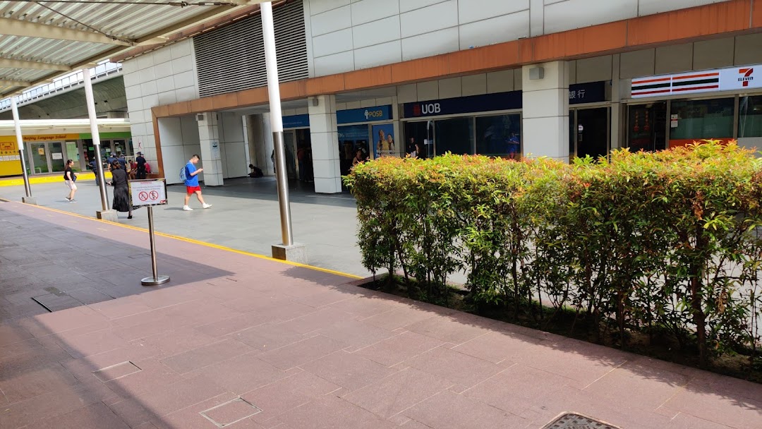 Exterior view of POSB, UOB, and 7-Eleven storefronts at Jurong Point, with people walking by.
