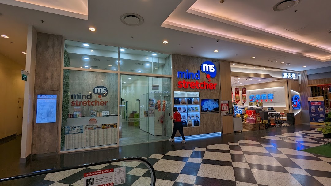 The brightly lit entrance of Mind Stretcher, an education center, within a bustling shopping mall.