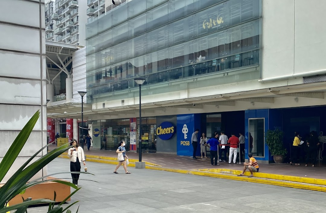 Exterior view of POSB Jurong Point Branch and Cheers convenience store with people queuing outside.