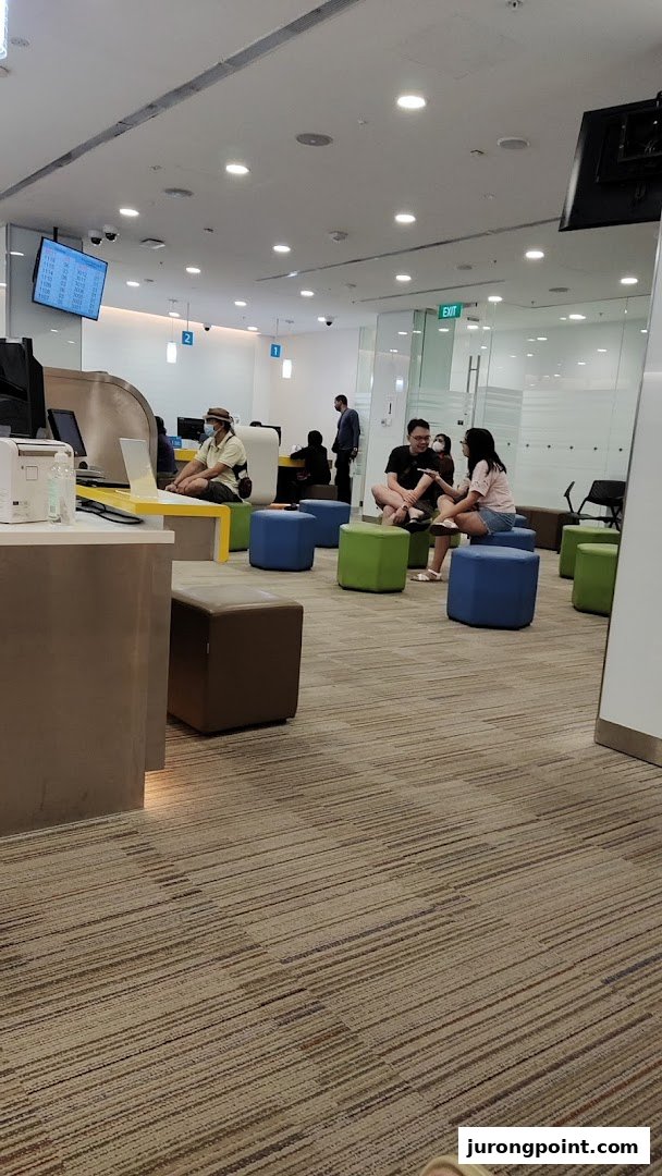Interior view of POSB Jurong Point Branch, showing customers in a modern waiting area and service counters.
