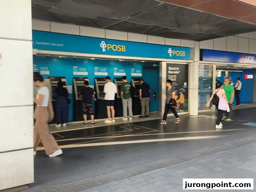 People are seen using ATMs outside the POSB Jurong Point Branch, with a UOB branch visible nearby.