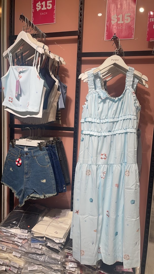 Light blue nautical-themed clothing, denim shorts, and packaged apparel displayed in Purpur shop.