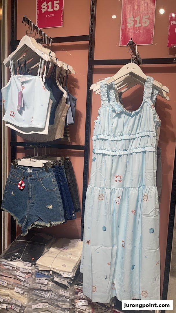 Light blue nautical-themed clothing, denim shorts, and packaged apparel displayed in Purpur shop.