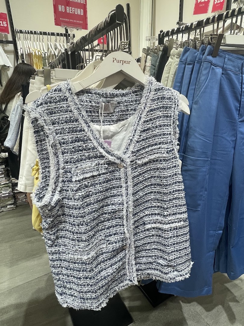 A stylish tweed-like vest on a hanger, showcasing Purpur's fashion collection.