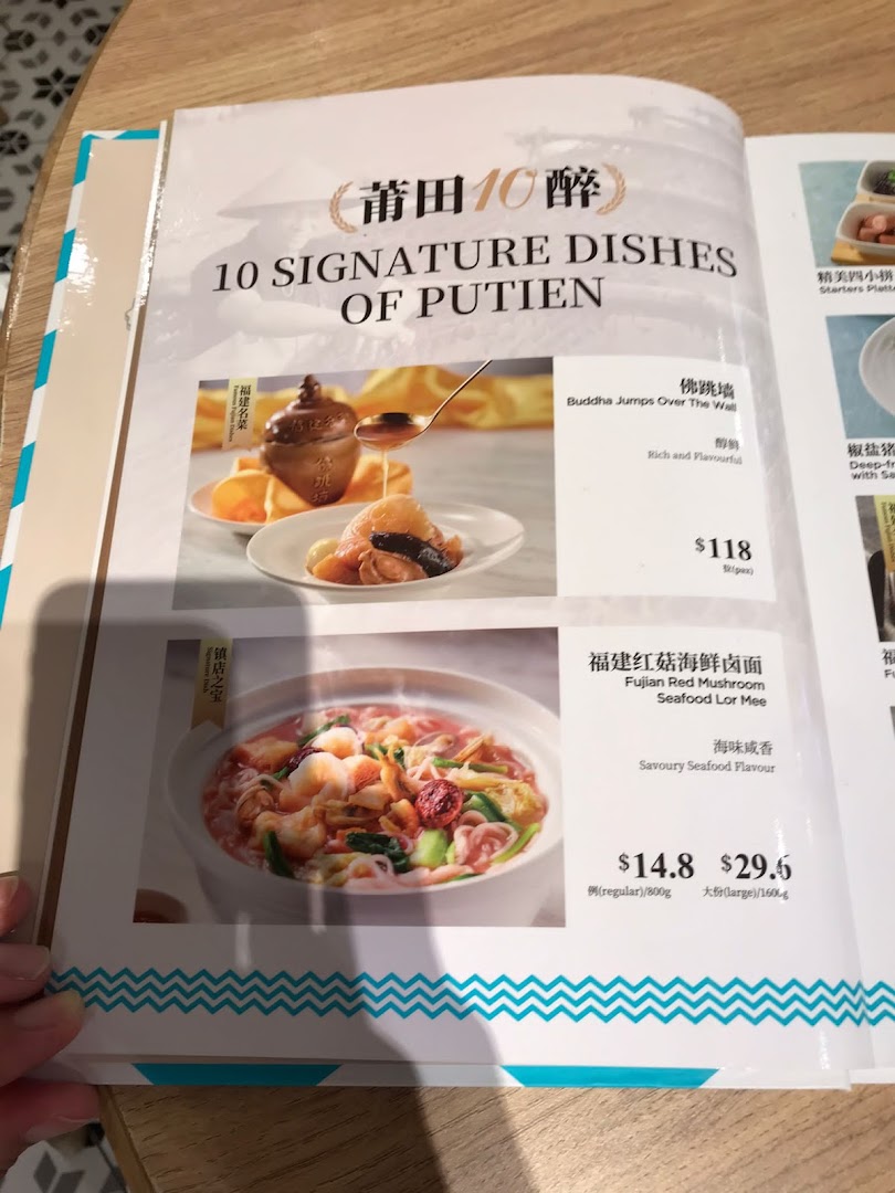A close-up of Putien's menu showcasing two signature dishes: Buddha Jumps Over The Wall and Fujian Red Mushroom Seafood Lor Mee.