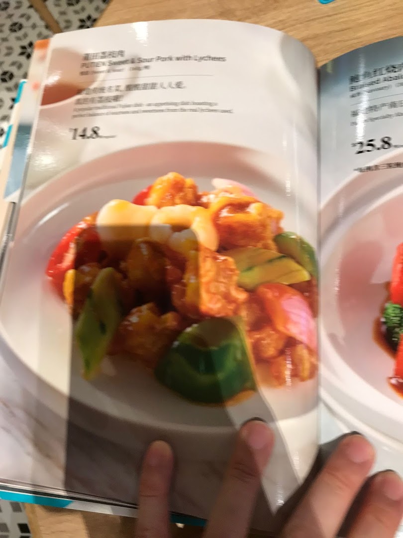 An open menu from PUTIEN showcasing Sweet & Sour Pork with Lychees and Braised Abalone.