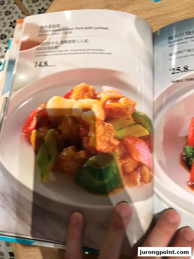 An open menu from PUTIEN showcasing Sweet & Sour Pork with Lychees and Braised Abalone.