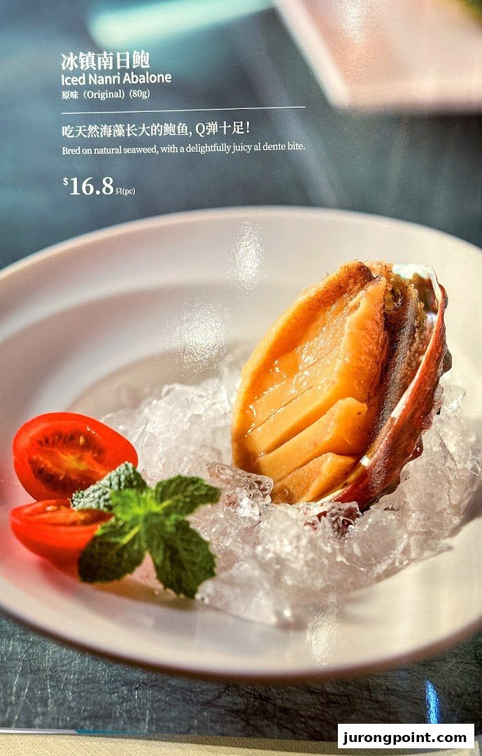 A close-up of Iced Nanri Abalone with cherry tomatoes and mint, displayed on a menu page with price.