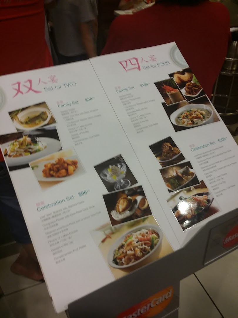 A menu stand displaying set meal options for two and four people with prices and food images.