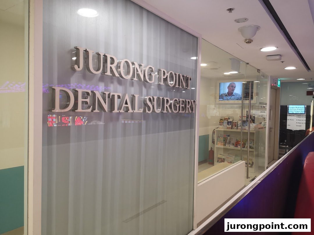The image shows the glass entrance of Jurong Point Dental Surgery with its prominent signage.