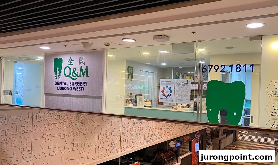 The exterior of Q&M Dental Surgery Jurong West, featuring its logo, signage, and contact number.