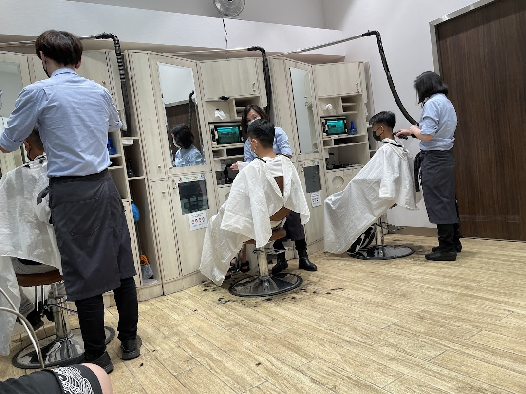 Customers receive quick haircuts from barbers in a clean, modern salon interior.