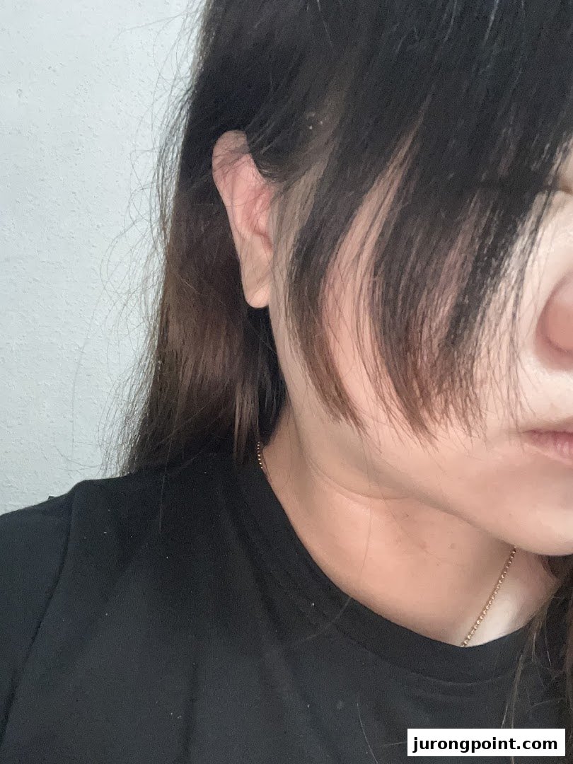Close-up of a person's ear and dark hair, suggesting a focus on hair services.