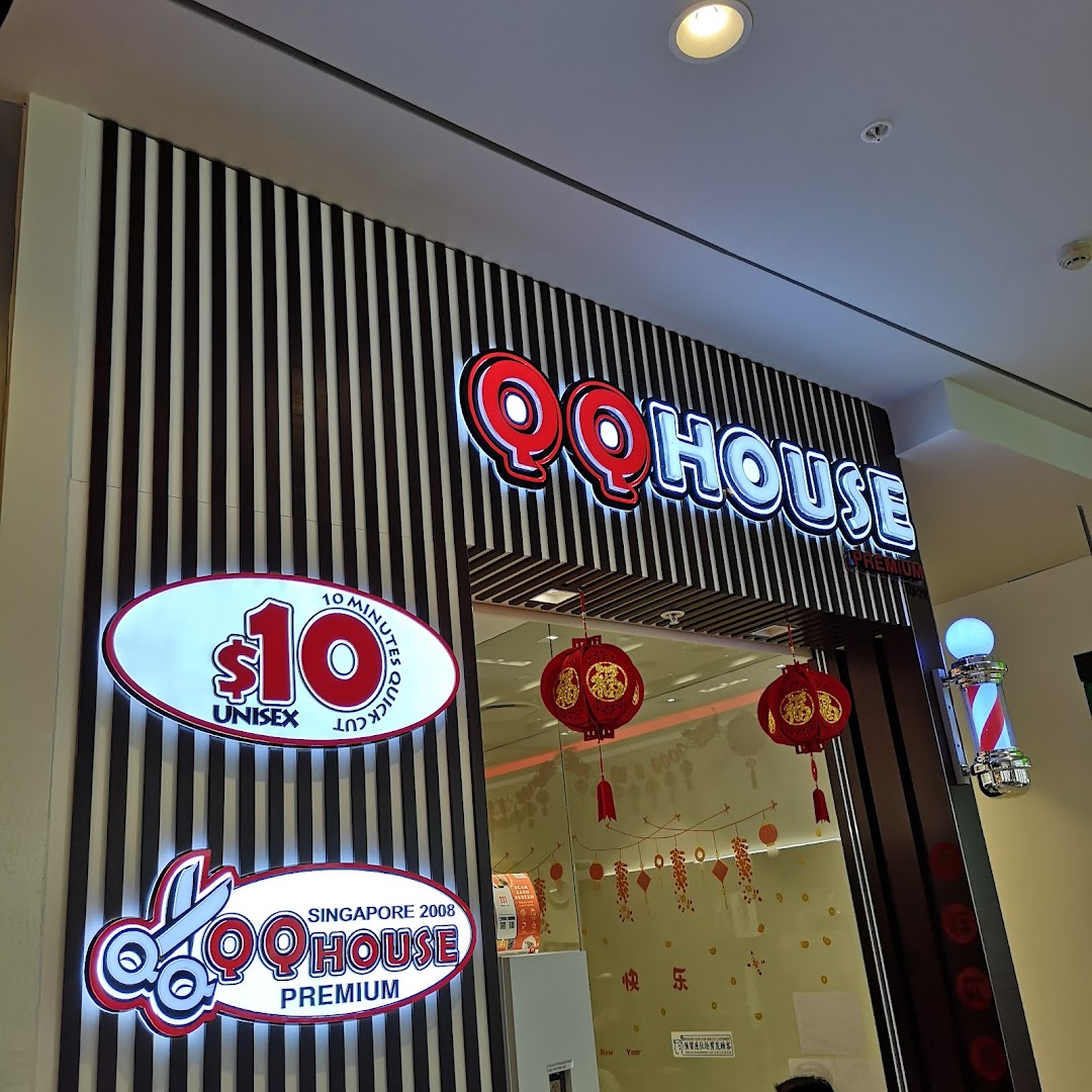 The illuminated storefront of QQ House, a hair salon offering quick unisex cuts.
