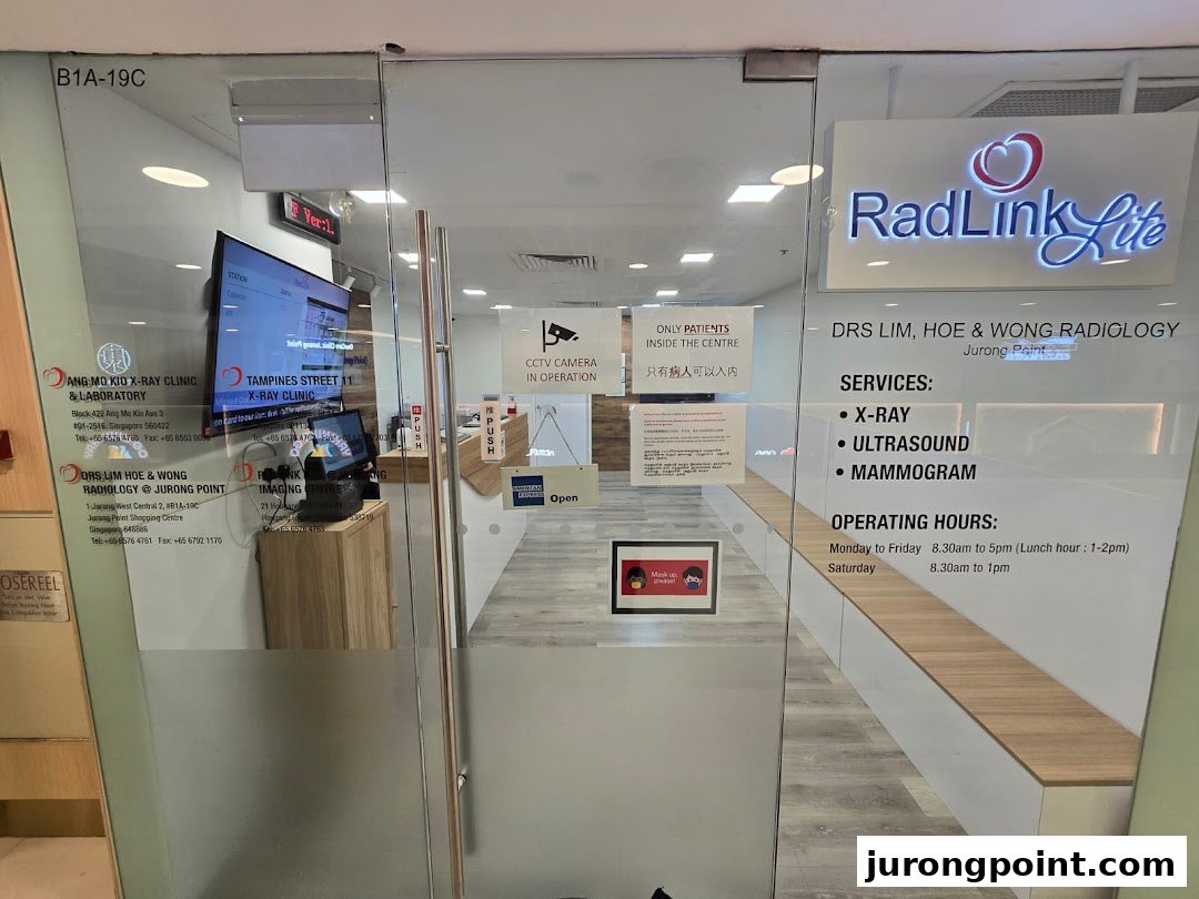 The glass entrance of RadLink Lite, Drs Lim, Hoe & Wong Radiology, displaying services and operating hours.