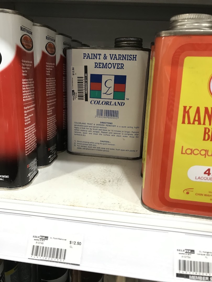 A close-up of paint and varnish remover cans on a shelf at Selffix DIY, with visible price tags.