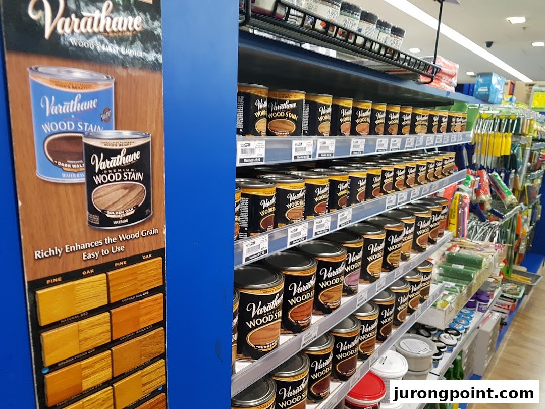 Shelves stocked with various Varathane wood stain products and a color sample display in a DIY store.