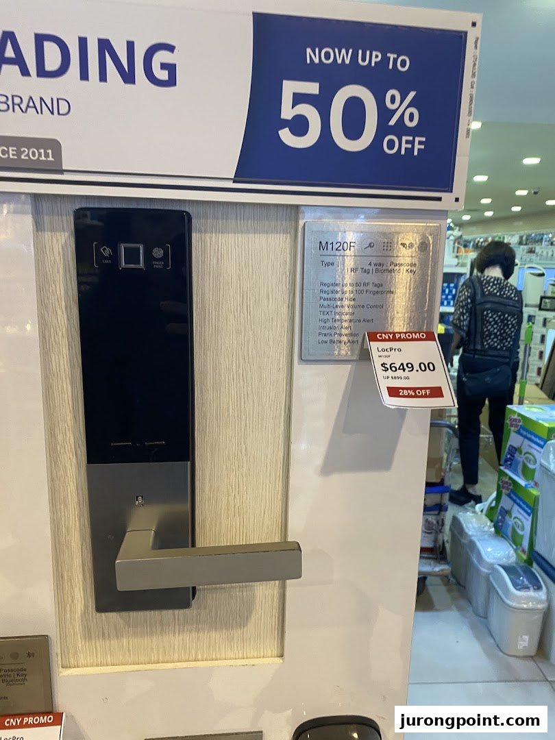 A smart door lock display with a promotional sign for up to 50% off at Selffix DIY.