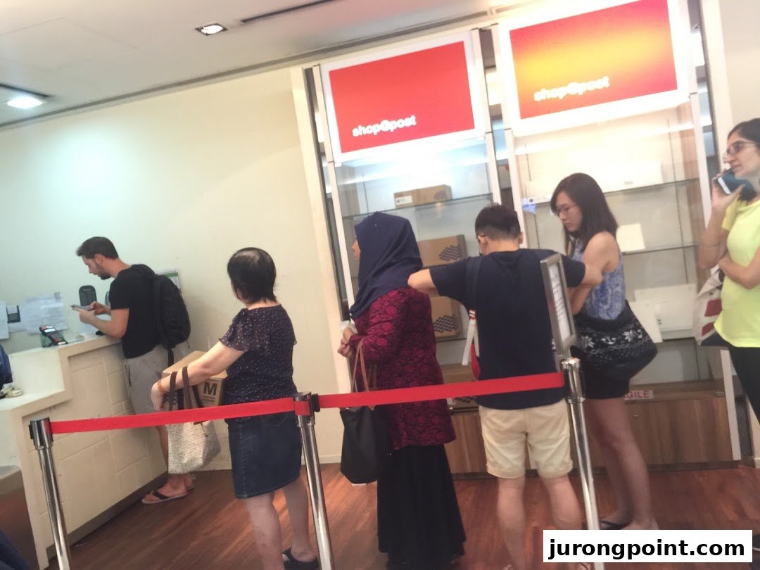 Customers queueing at service counters inside the Singapore Post Jurong Point branch.