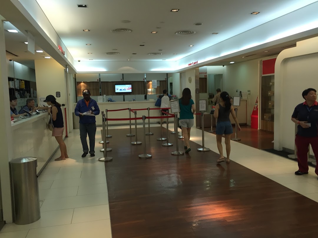 Customers queue and are served at counters inside the Singapore Post Jurong Point branch, offering various postal services.