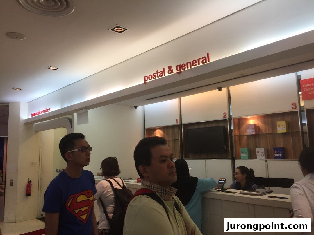Customers at service counters inside Singapore Post, offering postal, general, and financial services.