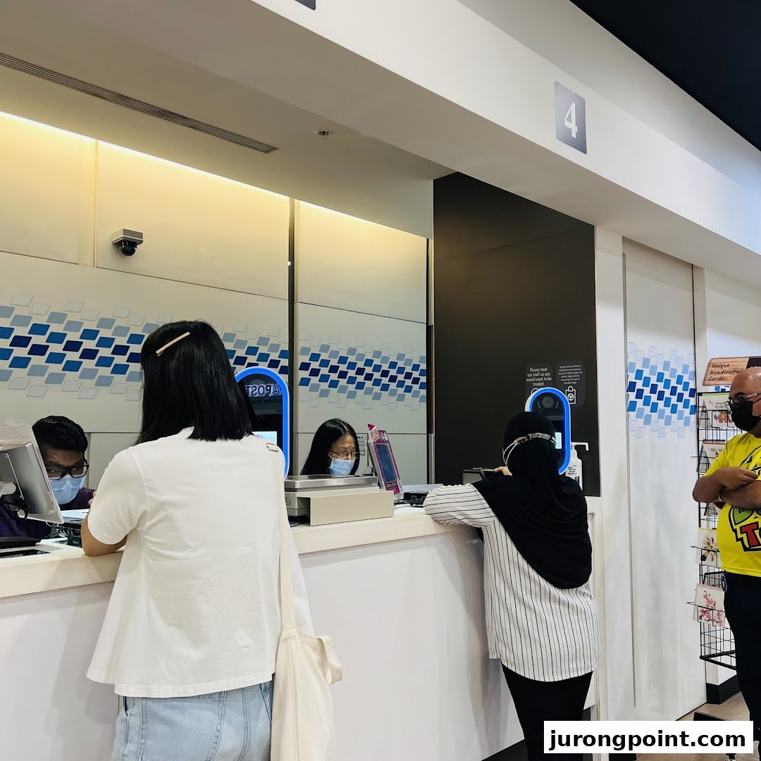 Customers are seen at the service counter of Singapore Post, receiving assistance from staff.