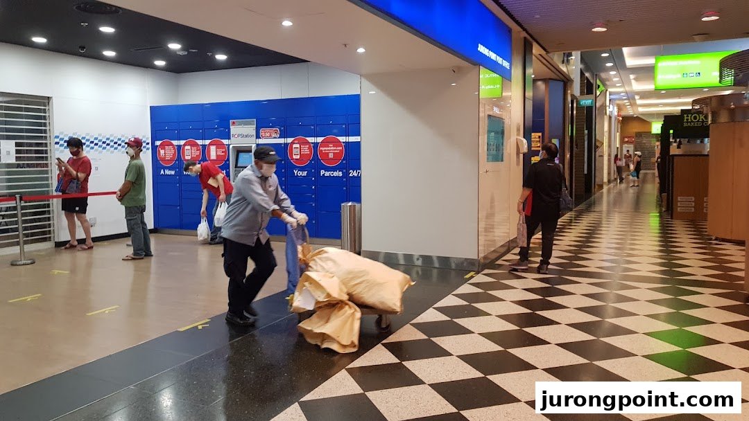 Customers and staff at the Singapore Post parcel locker station within Jurong Point mall.