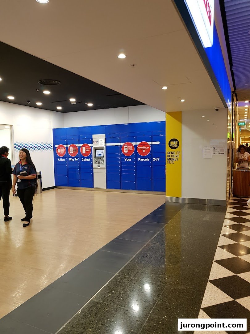 Interior view of Singapore Post's POPStation lockers for 24/7 parcel collection and sending, with a staff member present.