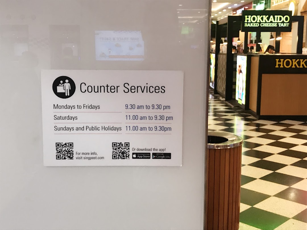 A sign for Singapore Post's counter services with operating hours and QR codes, set against a mall interior.