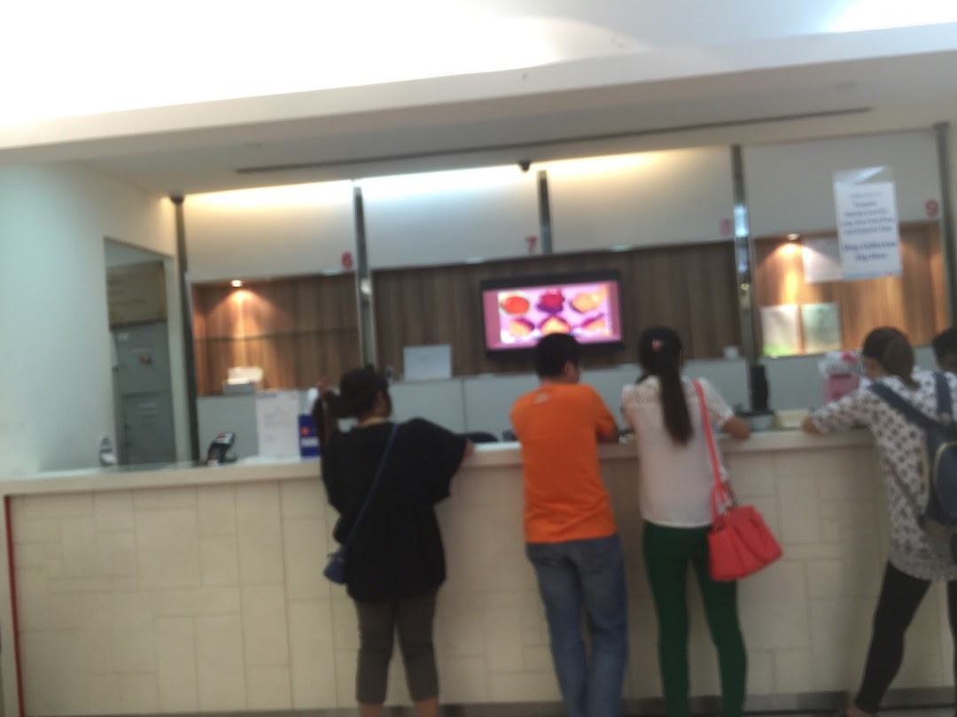 Customers are seen at the service counter of Singapore Post, with staff assisting them.