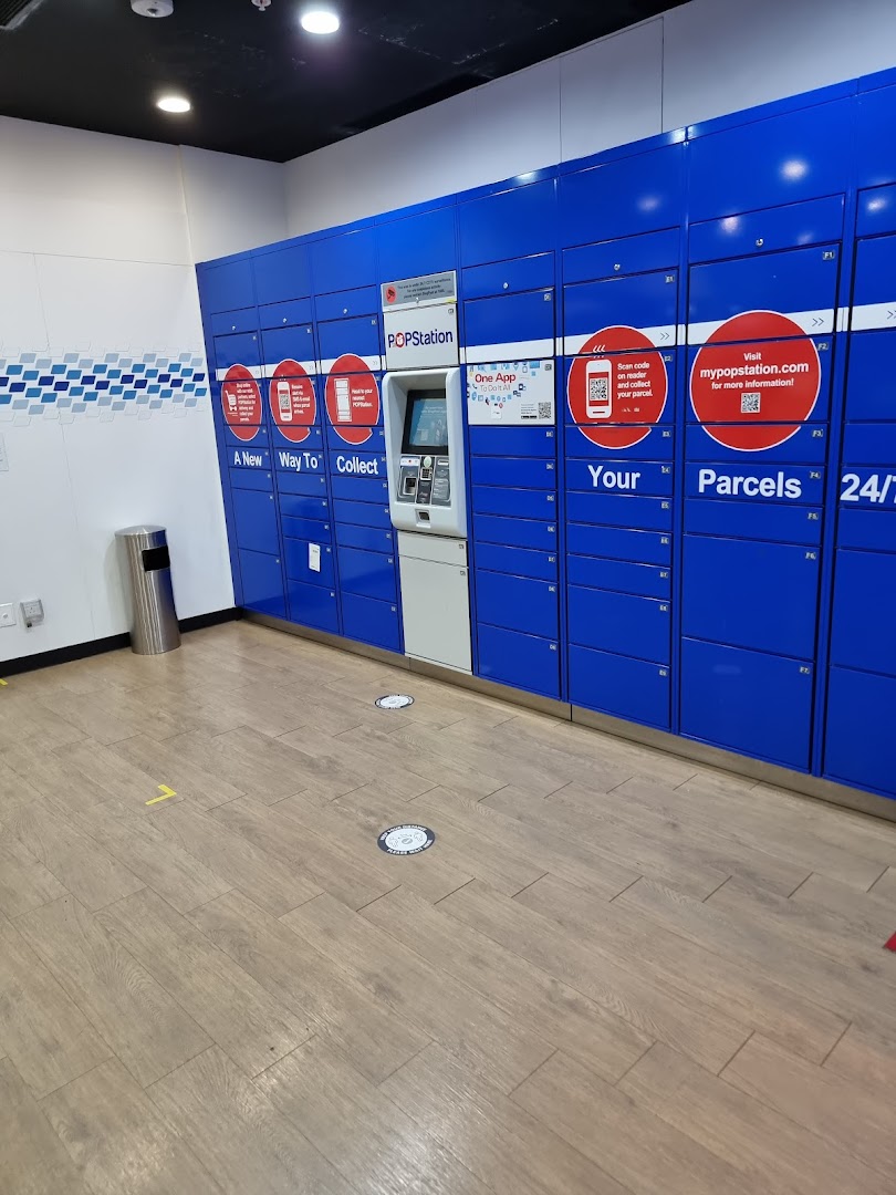 An interior view of blue POPStation parcel lockers with a central kiosk for convenient collection.